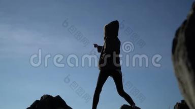 <strong>站在山顶</strong>上的女<strong>人</strong>。 女<strong>人</strong>在爬山后胜利地举起手臂